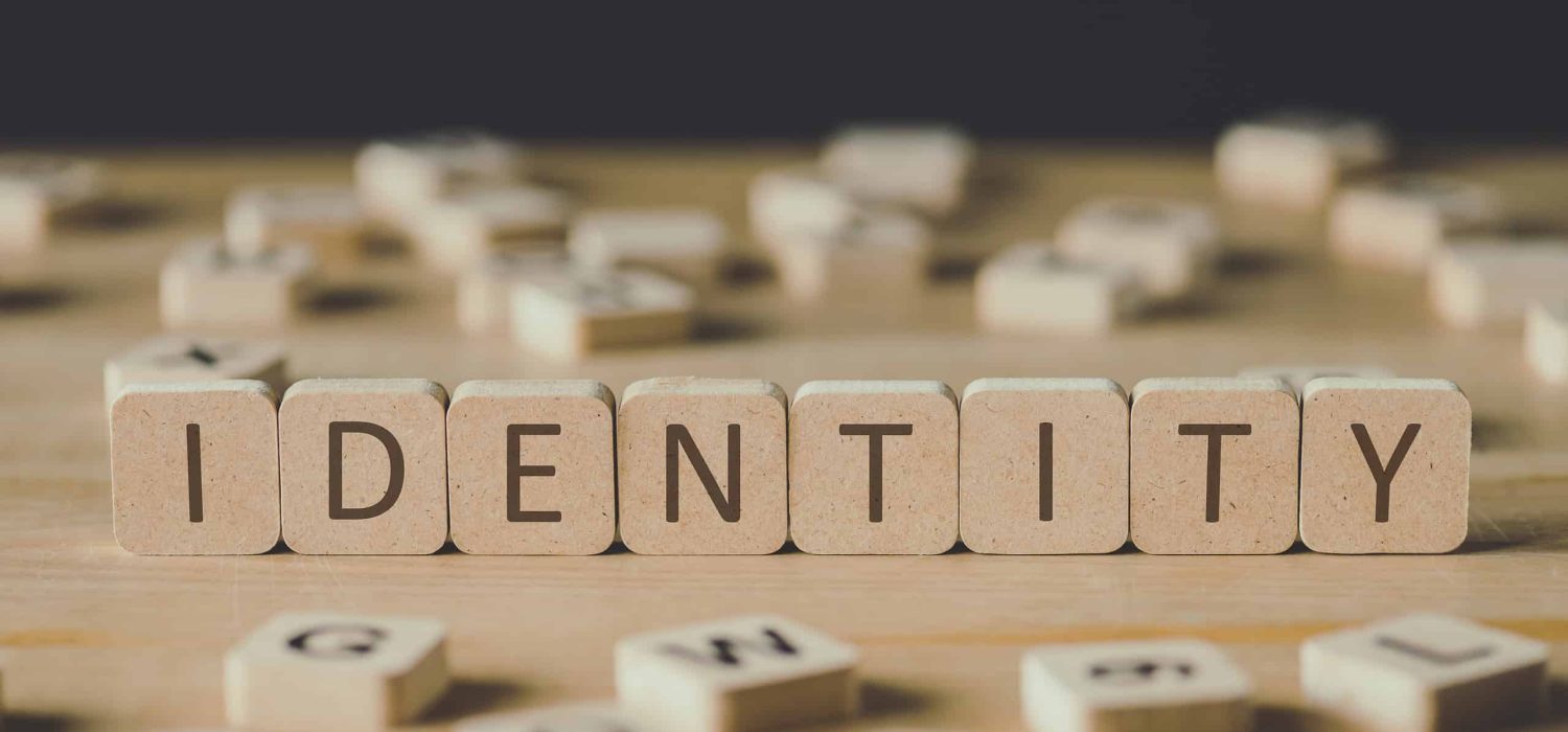 selective focus of word identity made of cubes surrounded by blocks with letters on wooden surface